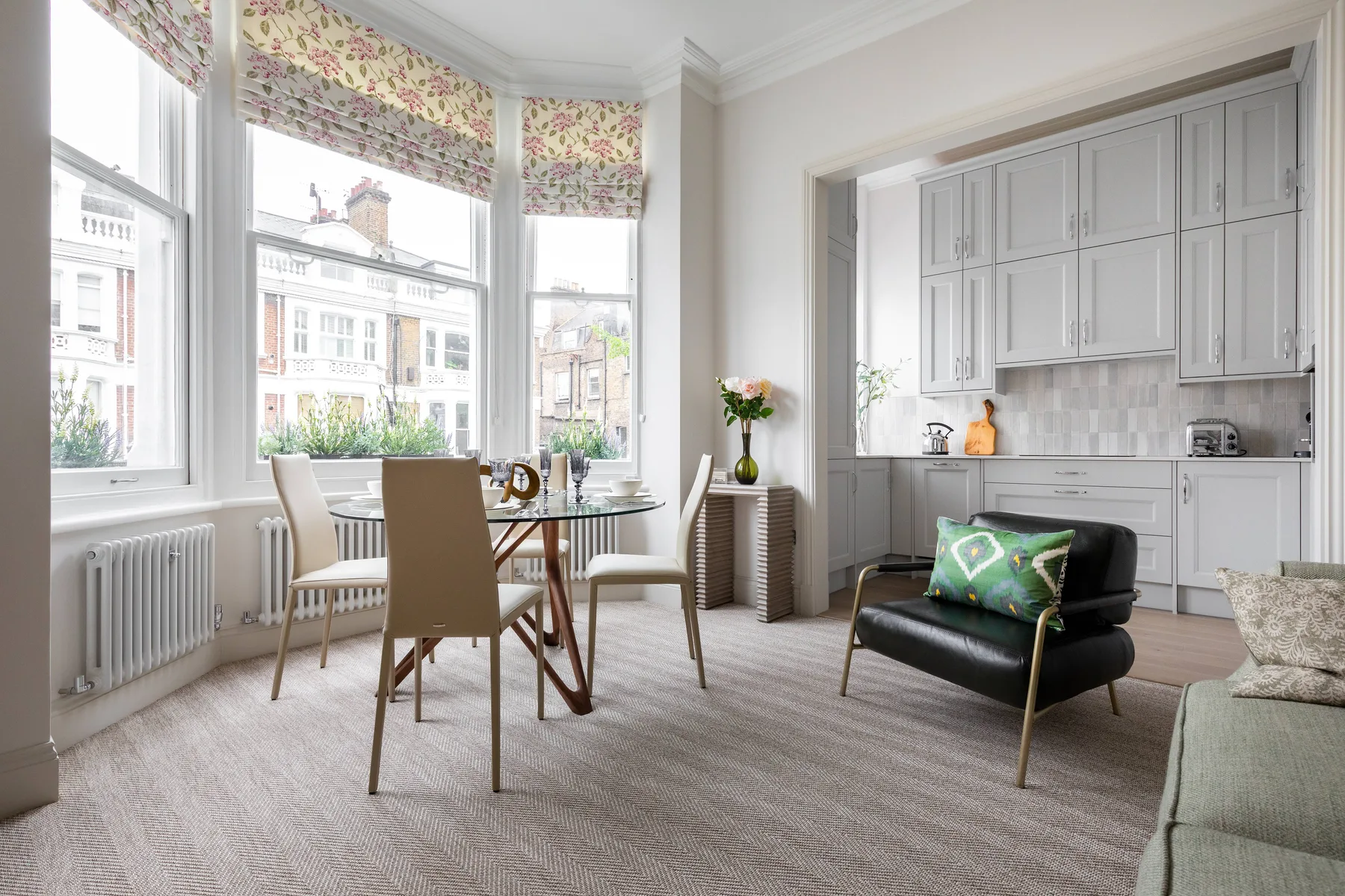 A bright living and dining area with large windows and an open kitchen.