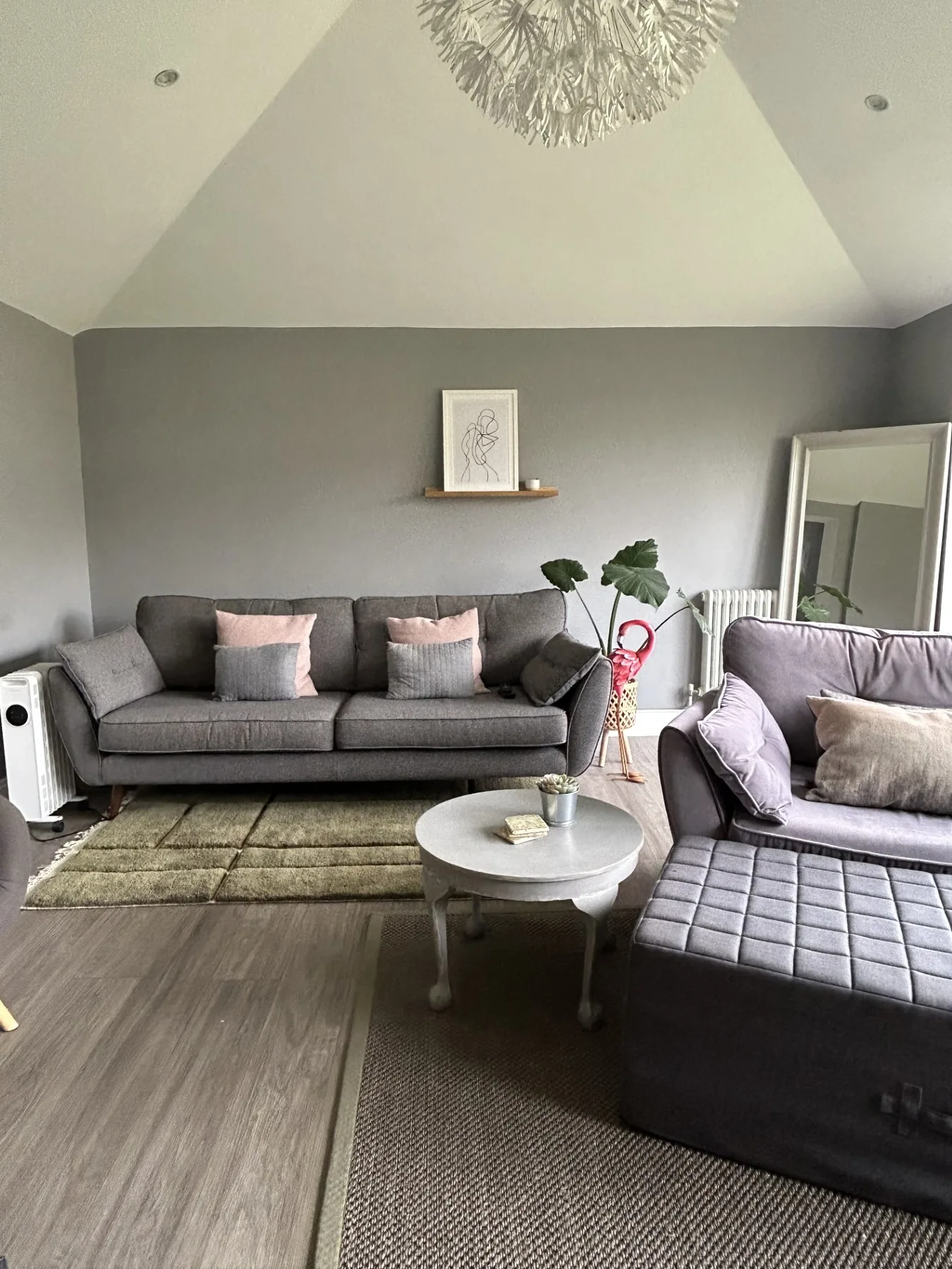 A living room with gray seating, a coffee table, and a large rug.