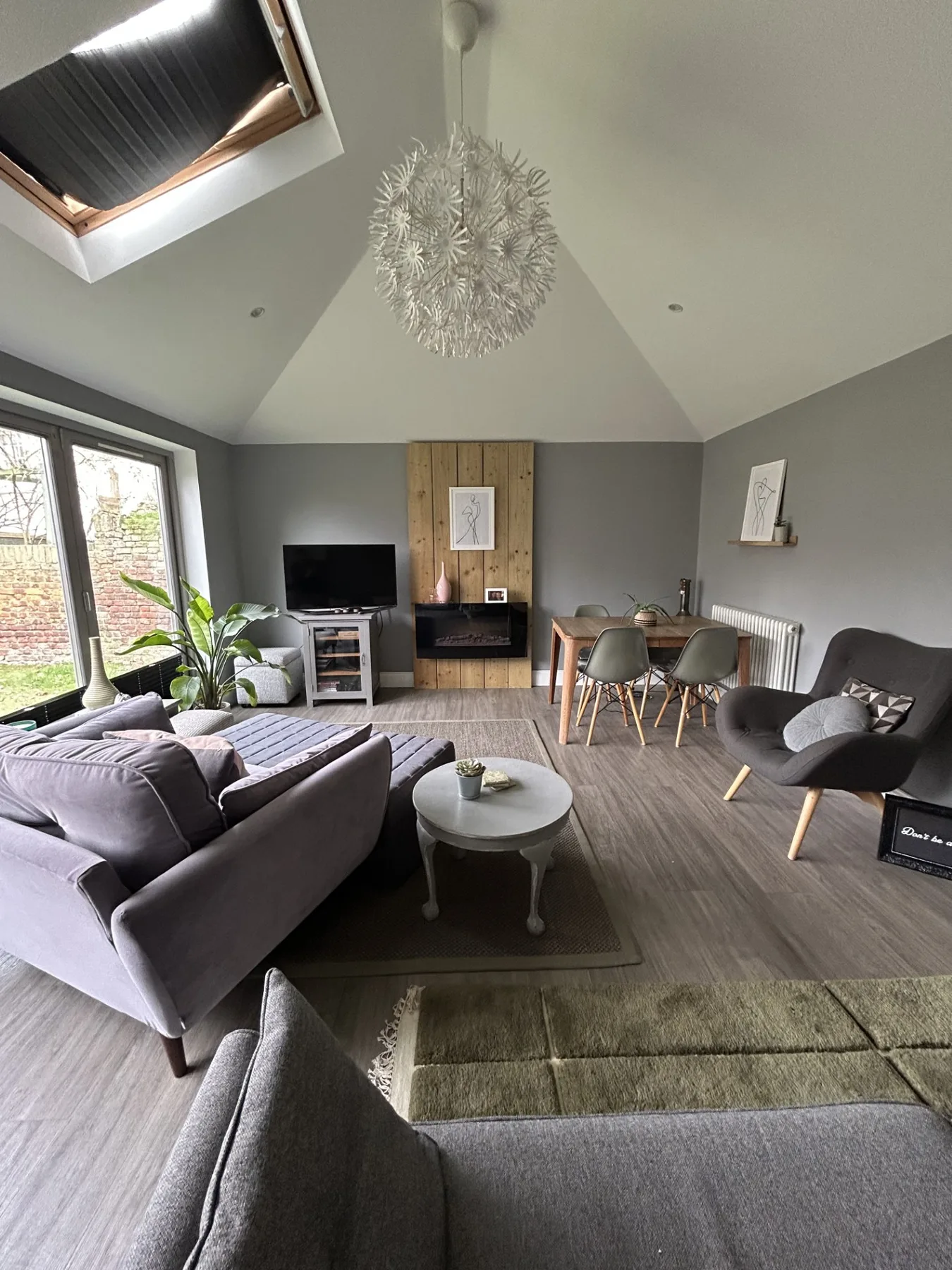 A bright living room with seating, a coffee table, and a dining area.