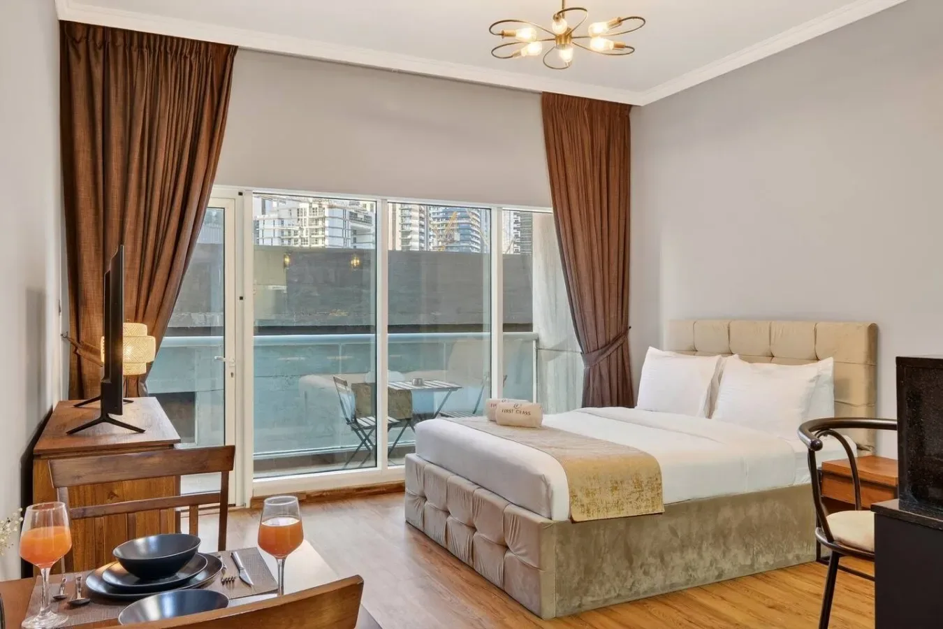 Un dormitorio con una cama grande junto a una puerta de vidrio que da a un balcón.