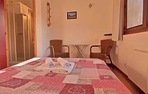 Habitación doble con colcha de retazos y ducha