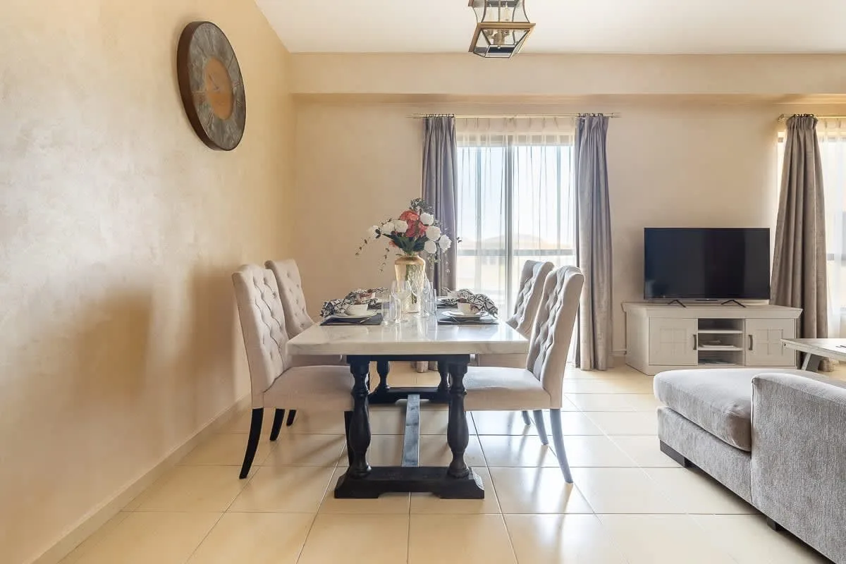 Un comedor y sala de estar con la mesa puesta y un televisor.