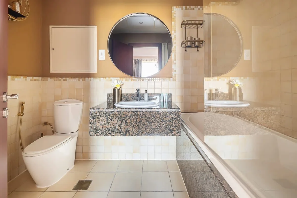 Un baño con azulejos, lavabo, inodoro y bañera.