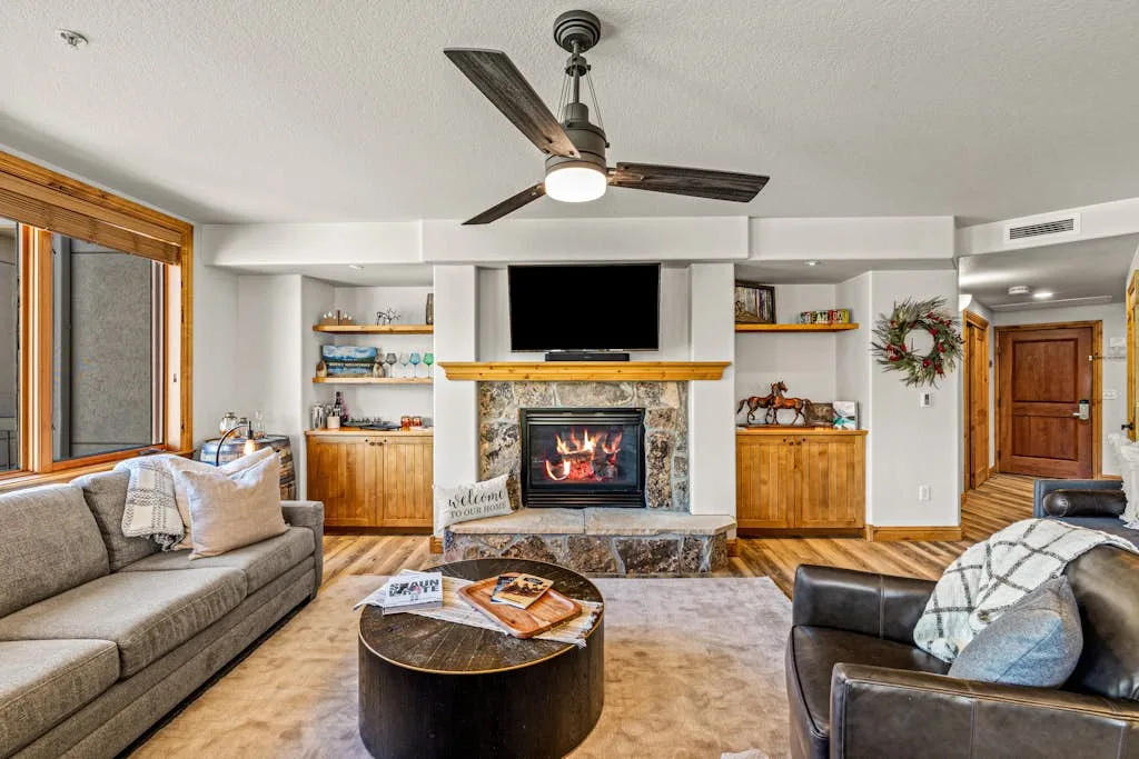 A living room with seating around a fireplace and television.