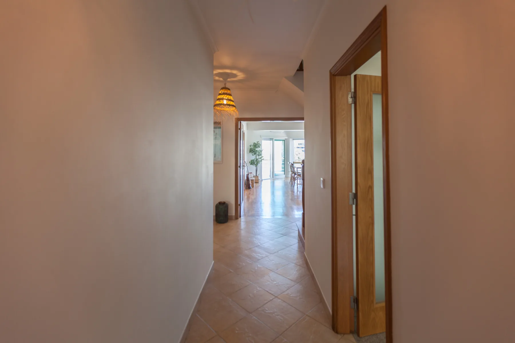 A tiled hallway leads toward a bright living area.