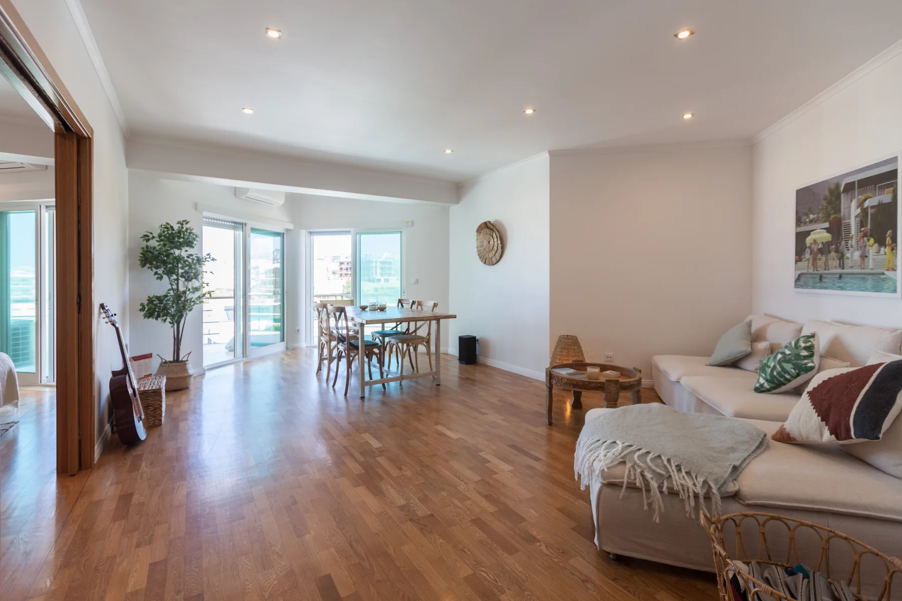 An open living and dining area with seating and glass doors opening onto a terrace.