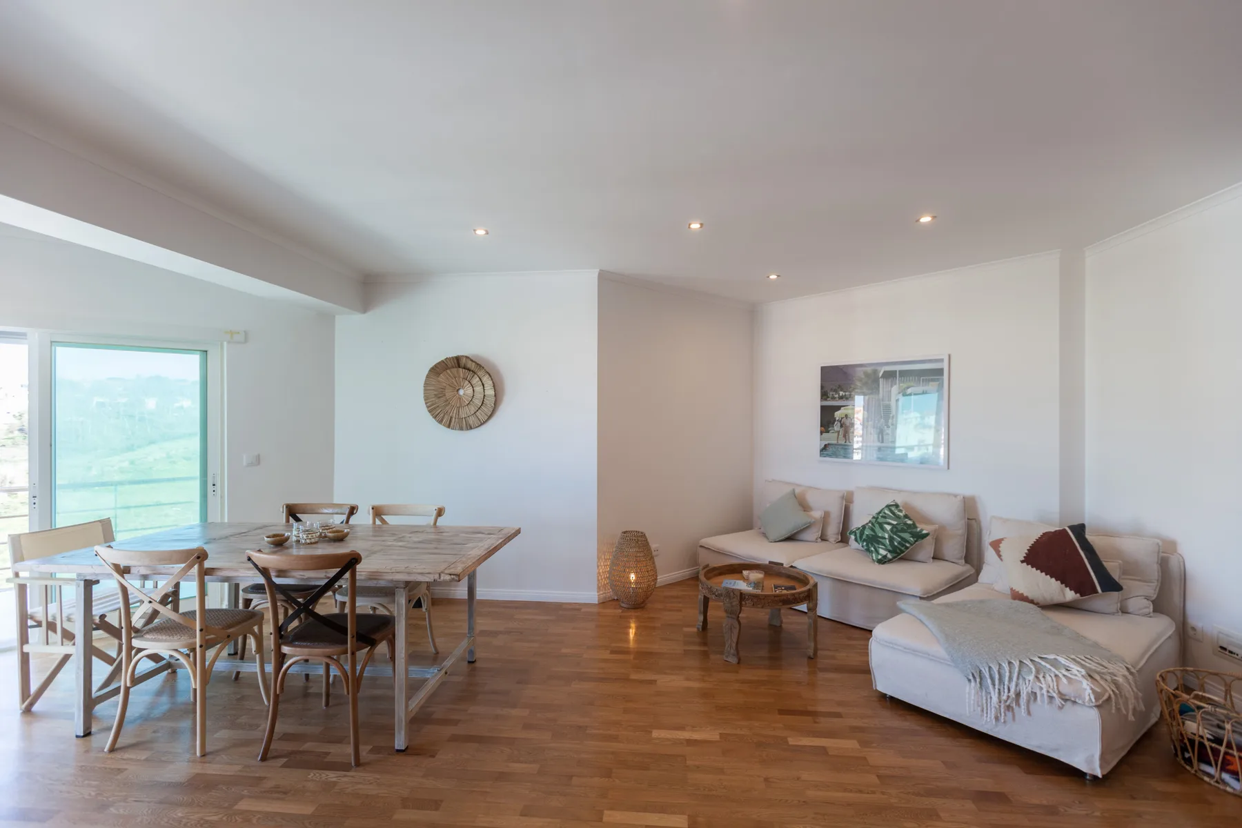 A living and dining area with seating beside a large window.