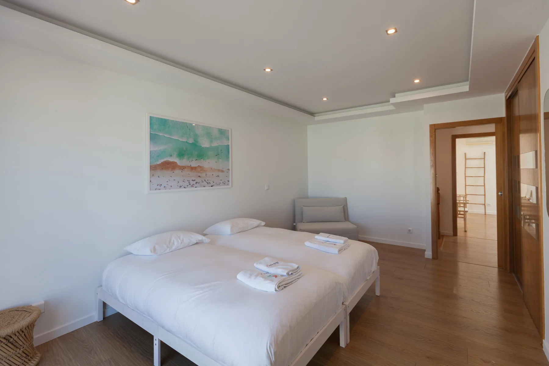 A bedroom with a neatly made bed and a colorful picture on the wall.
