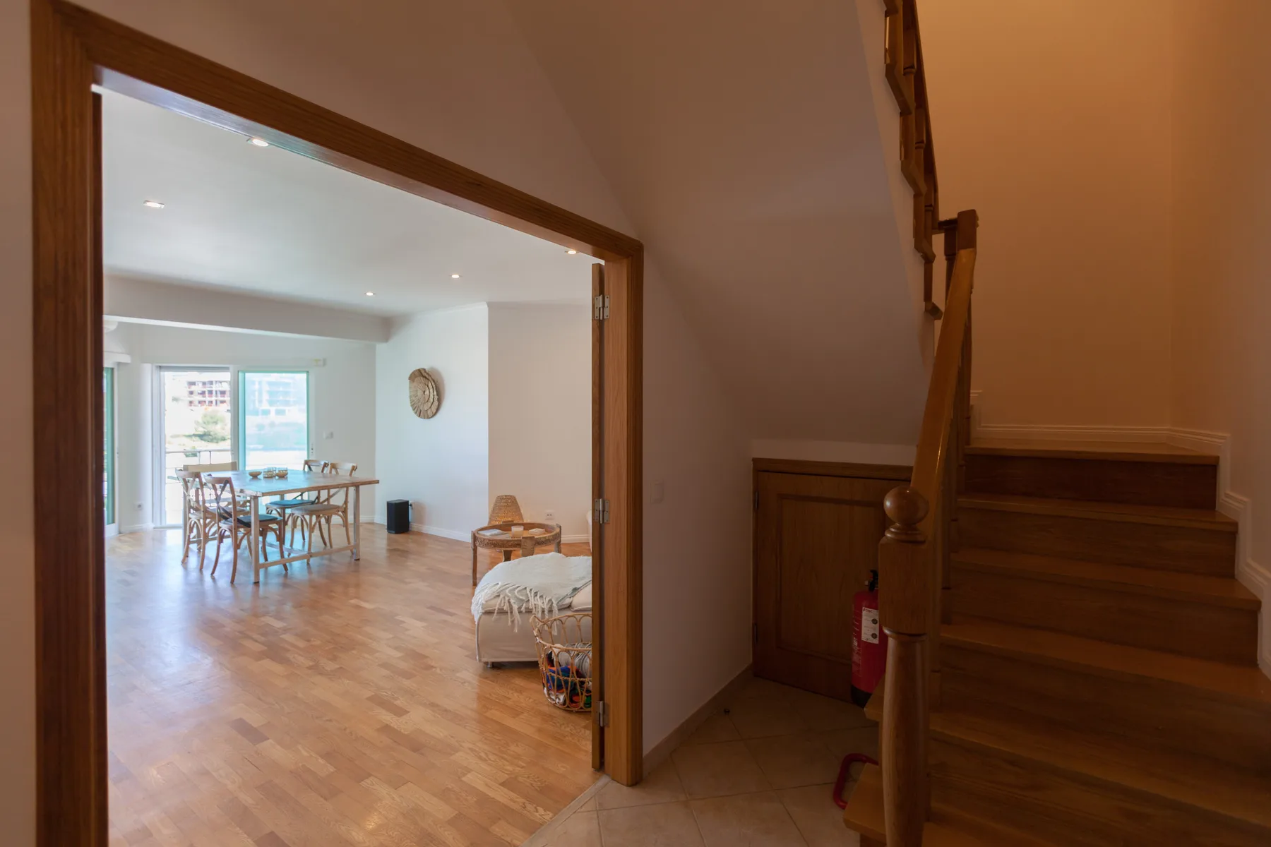 An interior doorway opens onto a dining area with a table and seating.