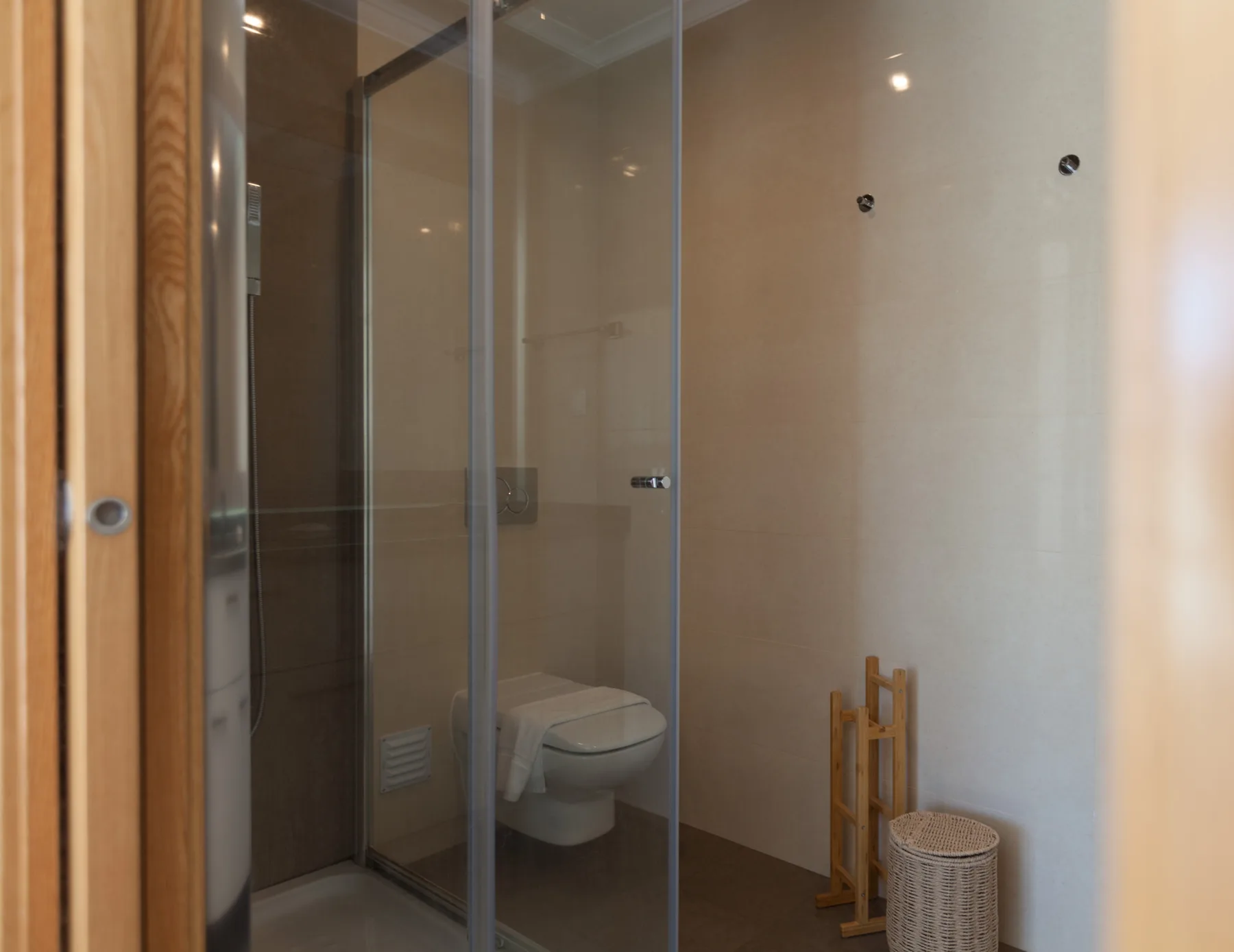 A bathroom with a glass-enclosed shower and toilet.