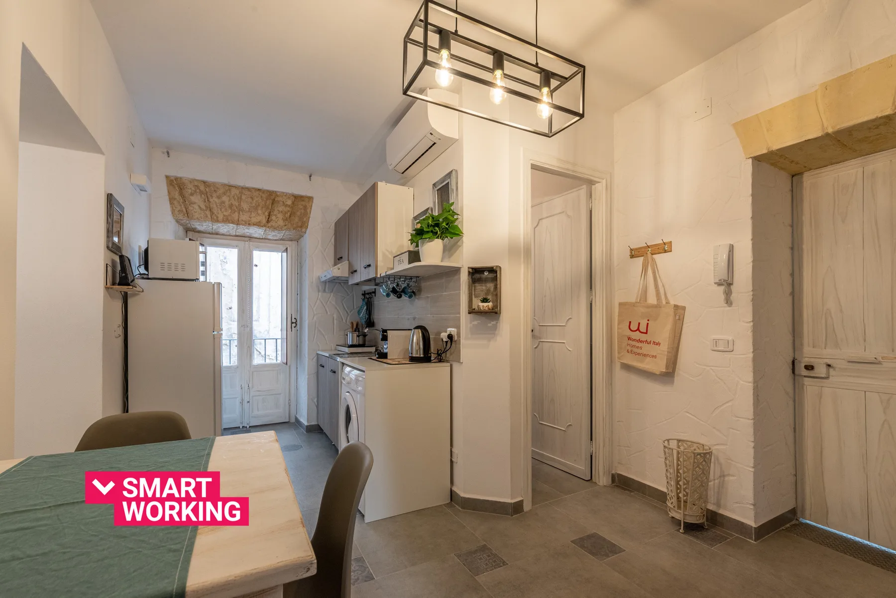 A compact kitchen and dining area with a table, cabinets, and a glass door.