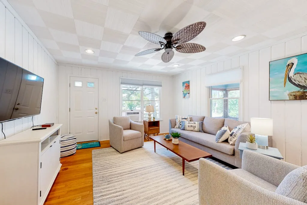 Bright living room with a sofa, armchairs, and a coffee table.