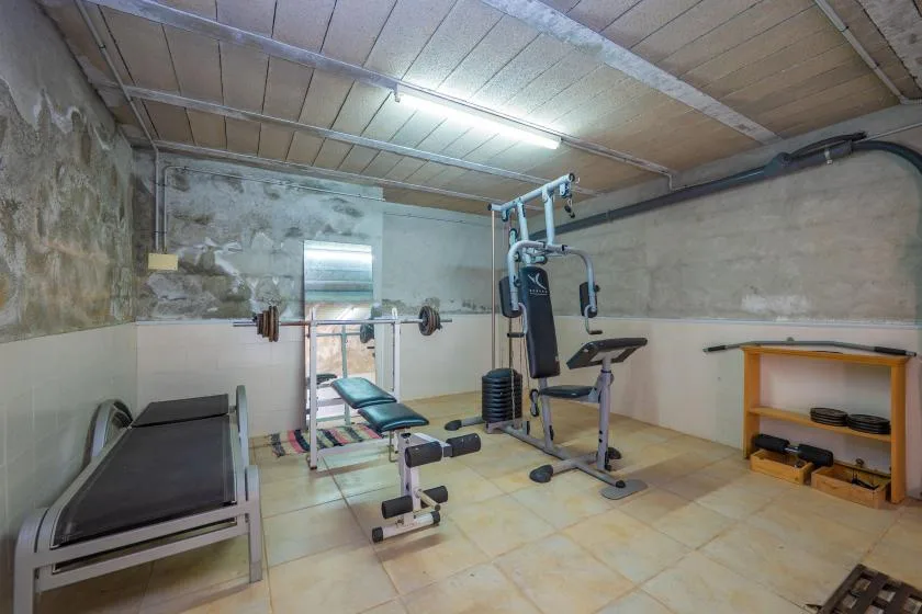 Un gimnasio en casa con equipo de ejercicio y una cinta de correr.