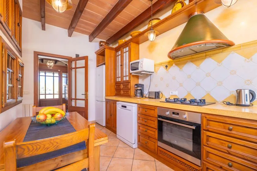 Una cocina cálida con armarios de madera, una cocina y una mesa de comedor.