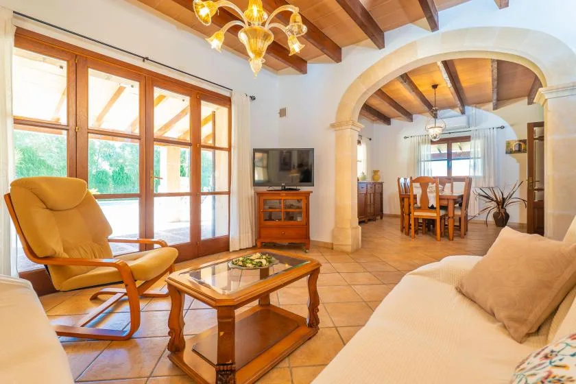 Una sala de estar con asientos, una mesa de centro y grandes ventanas.