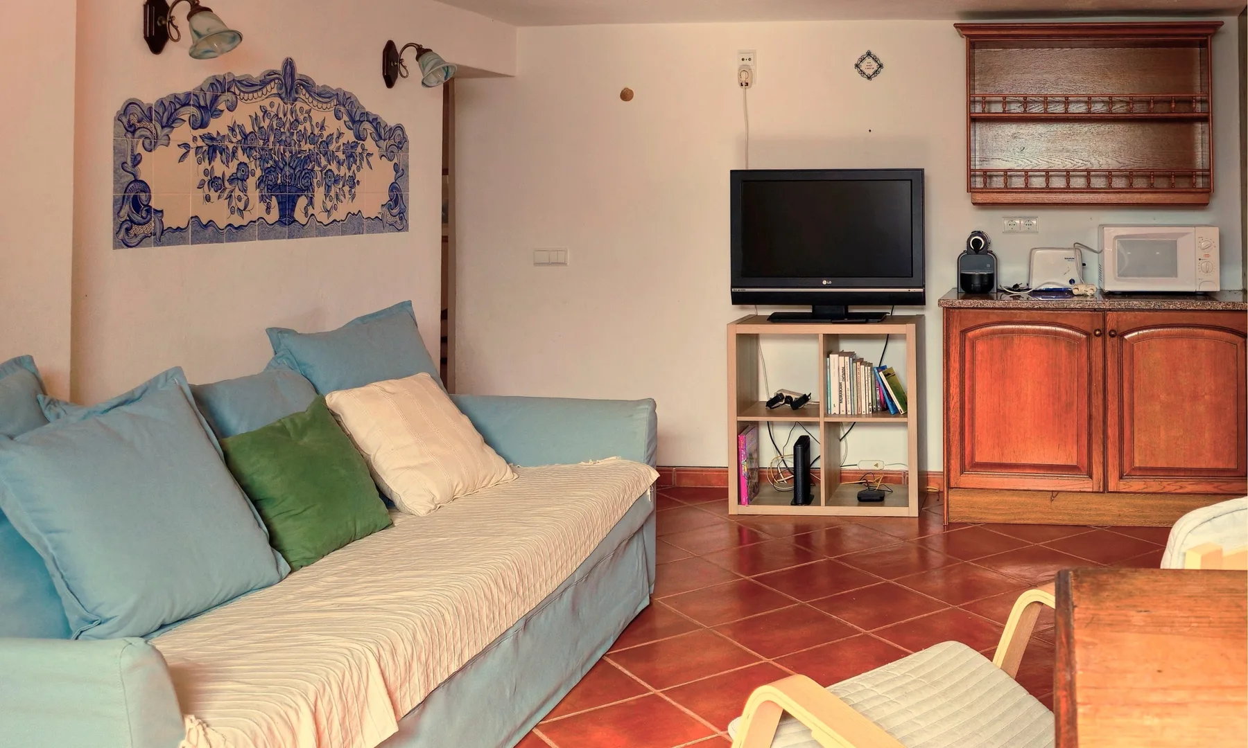 Una sala de estar con asientos, un televisor y armarios de madera.