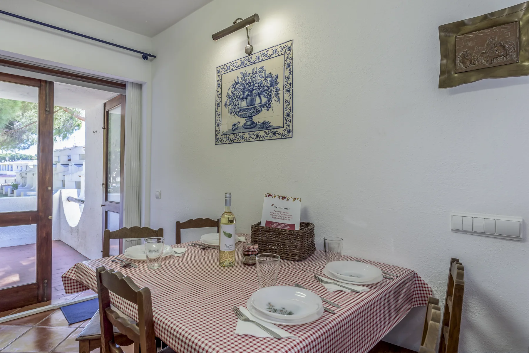 Un comedor con una mesa puesta con platos y vasos.