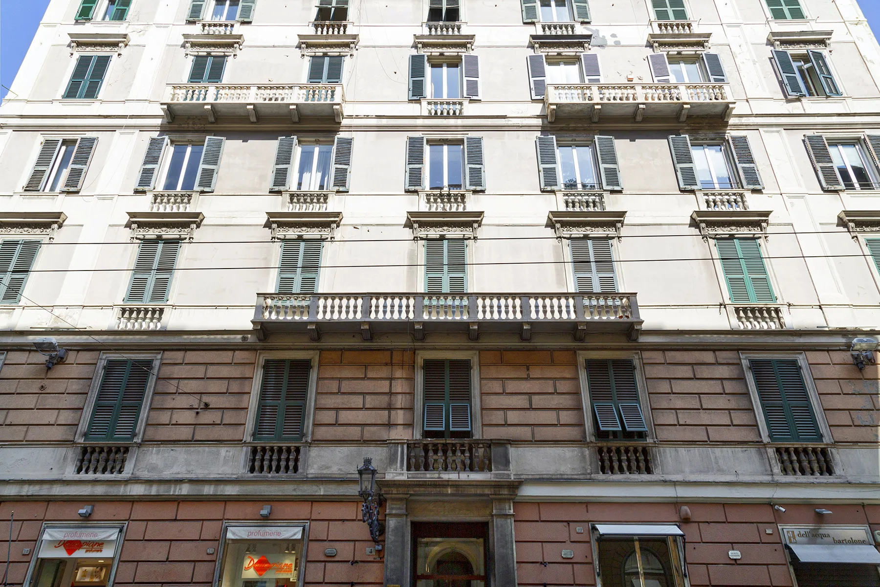 Fachada de un edificio de varios pisos con filas de ventanas y balcones.