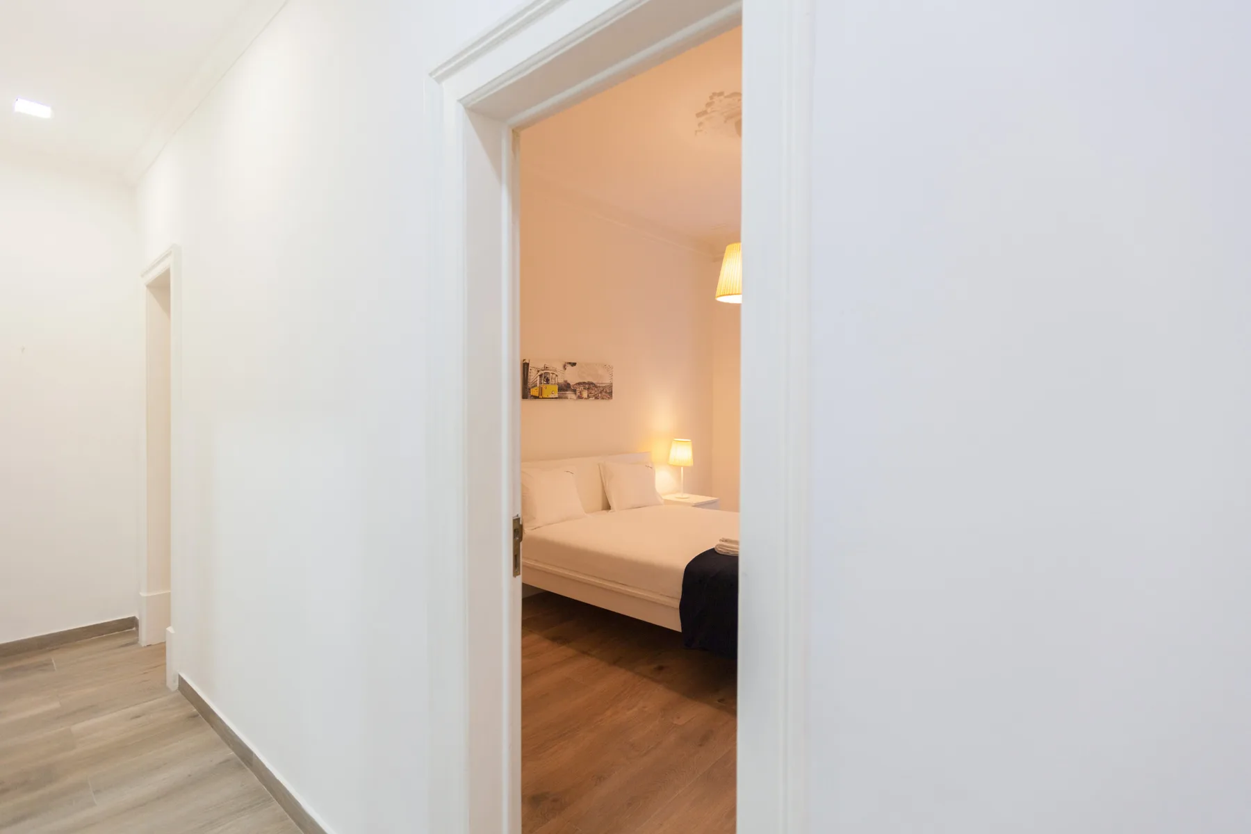 A bedroom with a bed is visible through an open doorway.