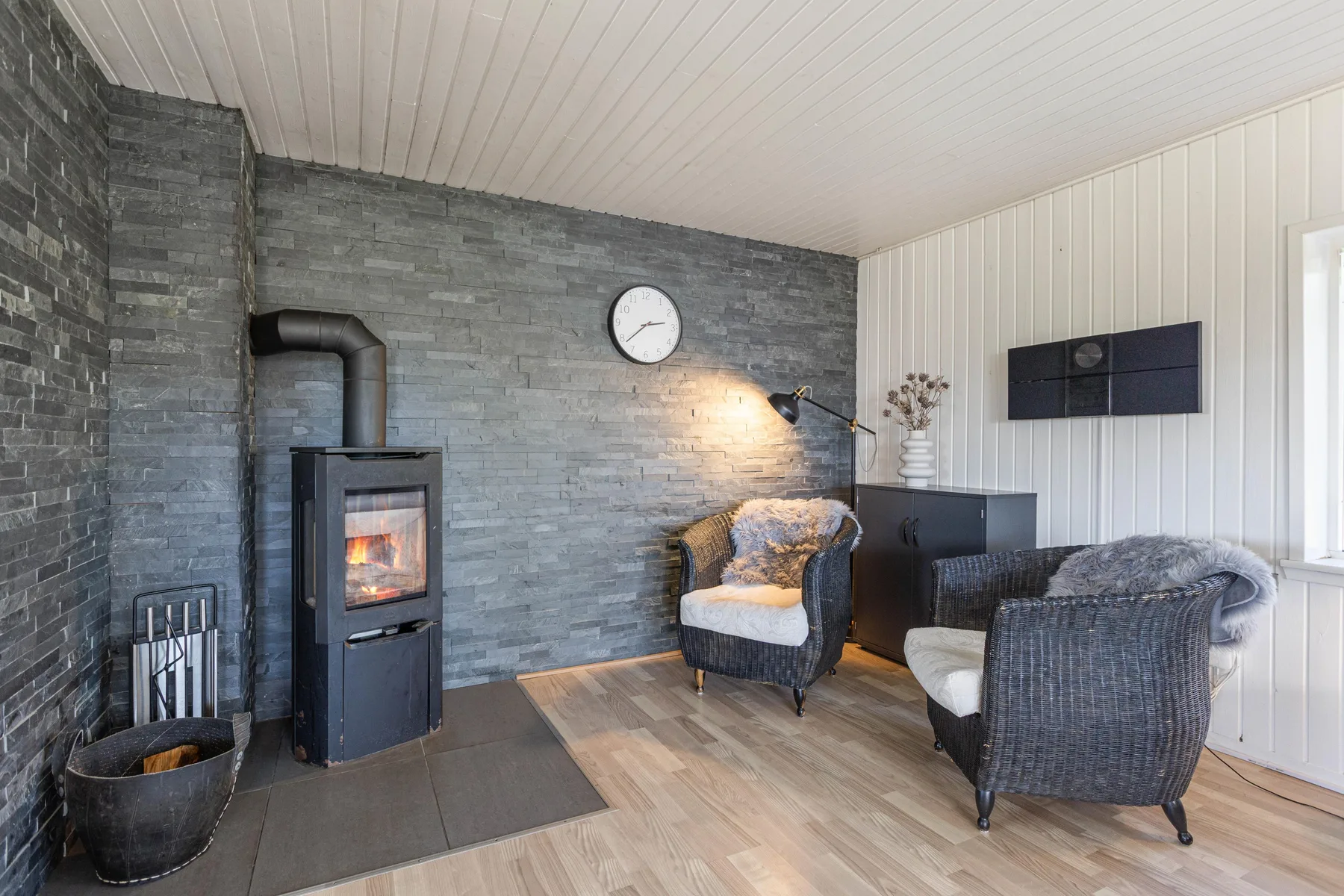 A living room with a wood-burning stove and seating.