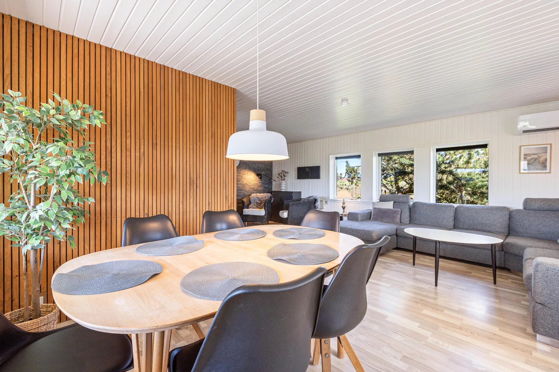 A bright living and dining area with a large table and seating.