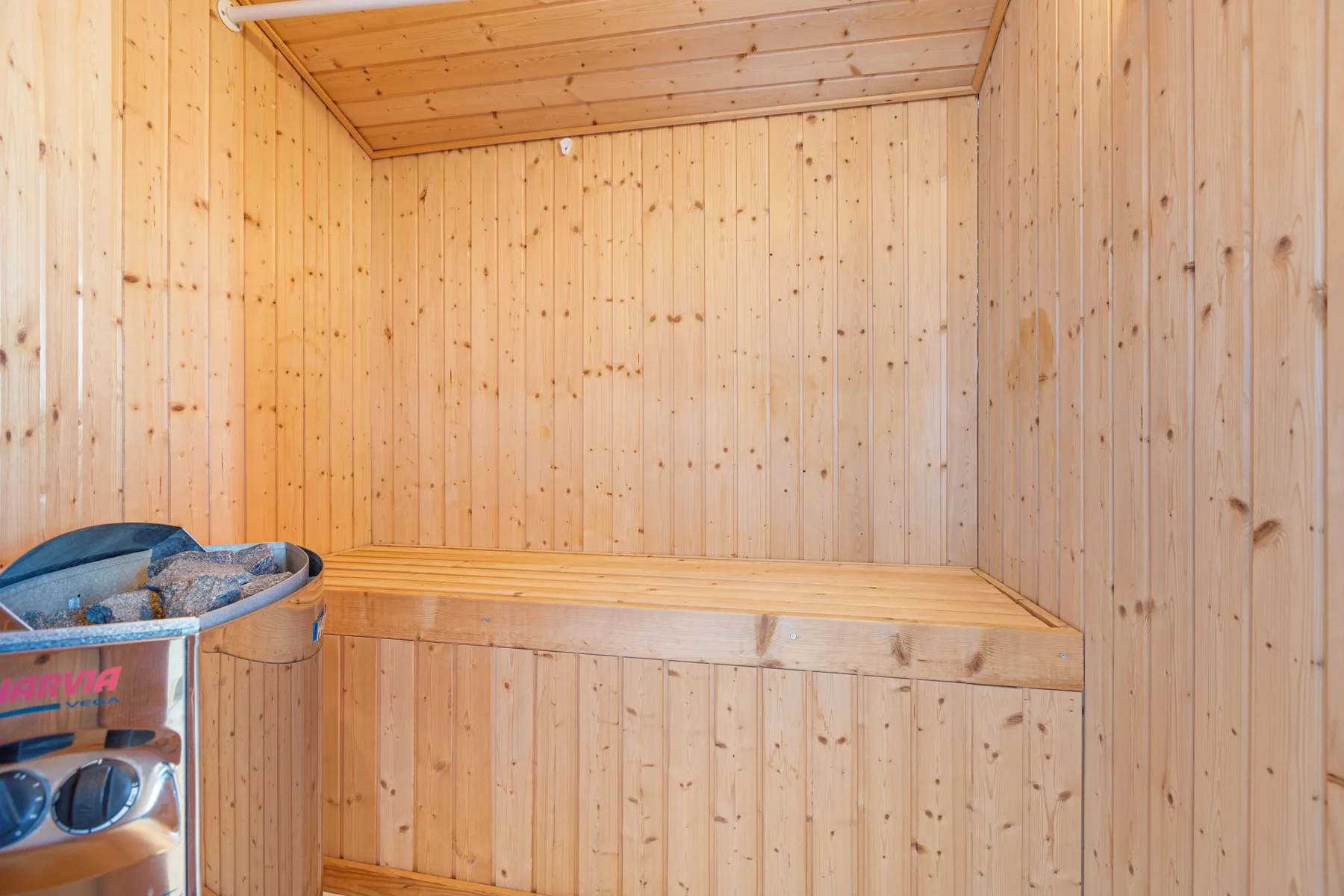 A wood-paneled sauna room with a raised wooden bench.