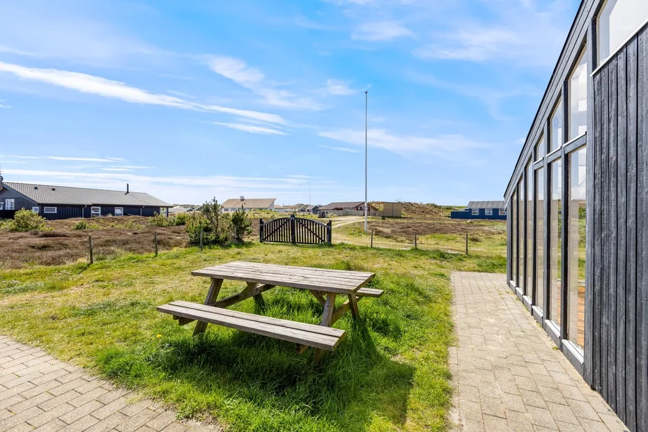 An outdoor seating area with a picnic table beside a modern building.