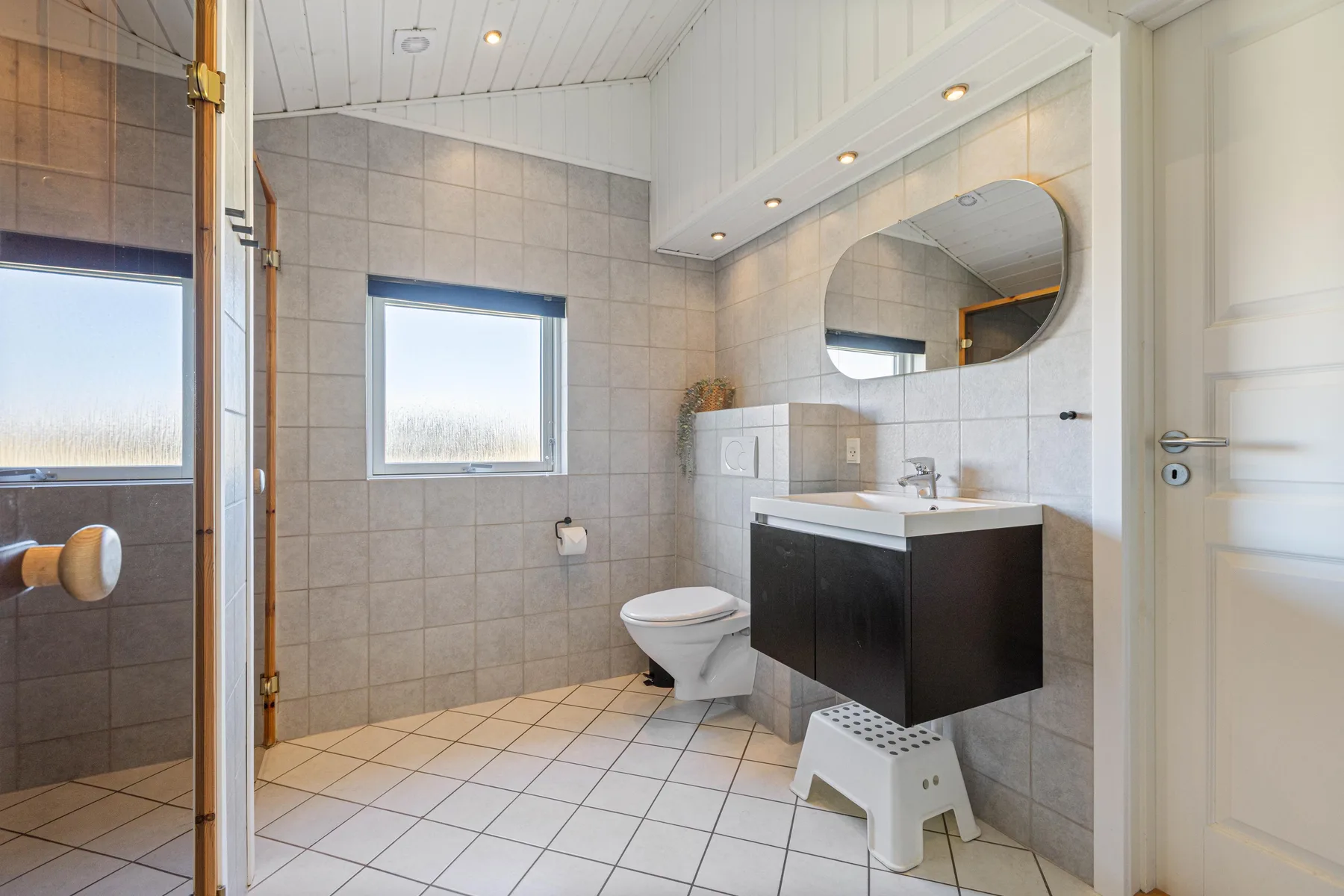 A tiled bathroom with a sink, toilet, and shower.