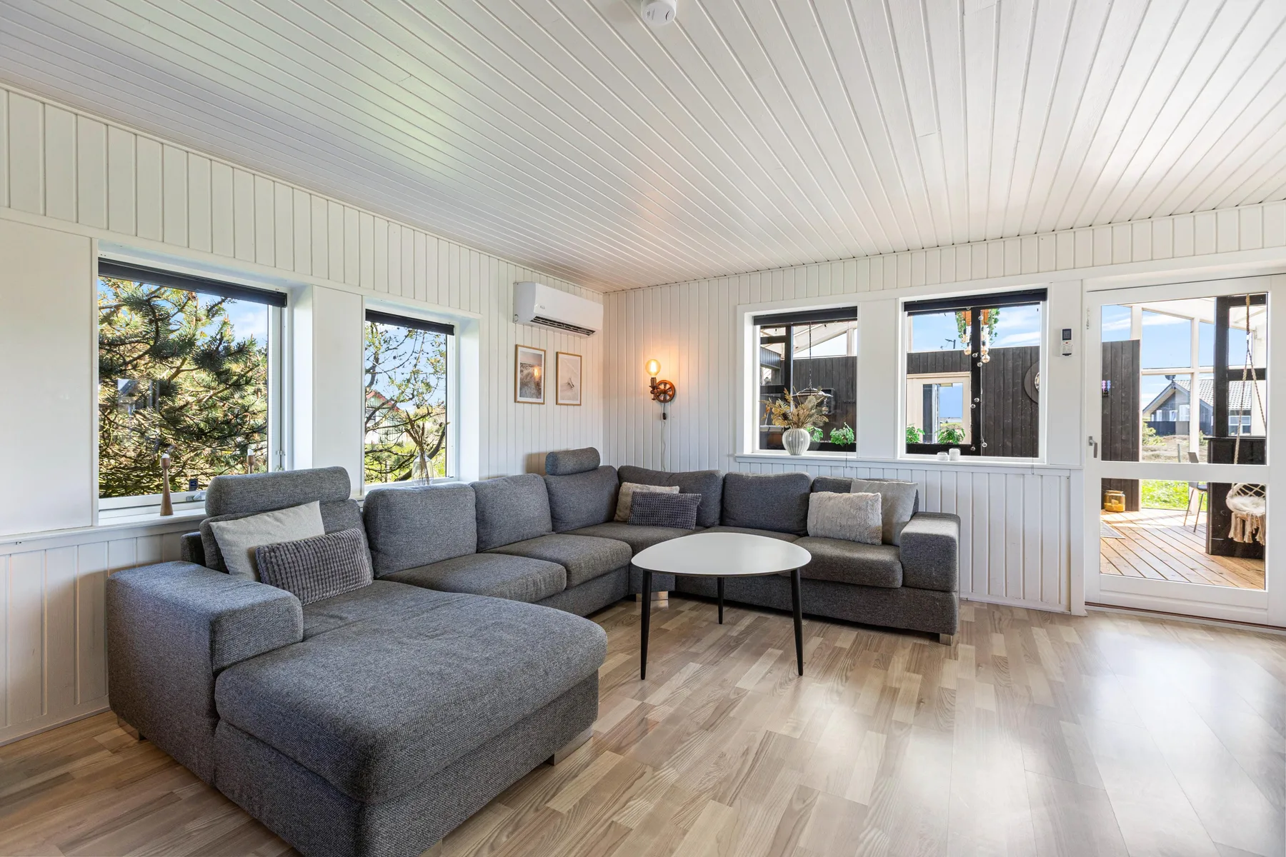 A bright living room has gray seating arranged around a low coffee table.