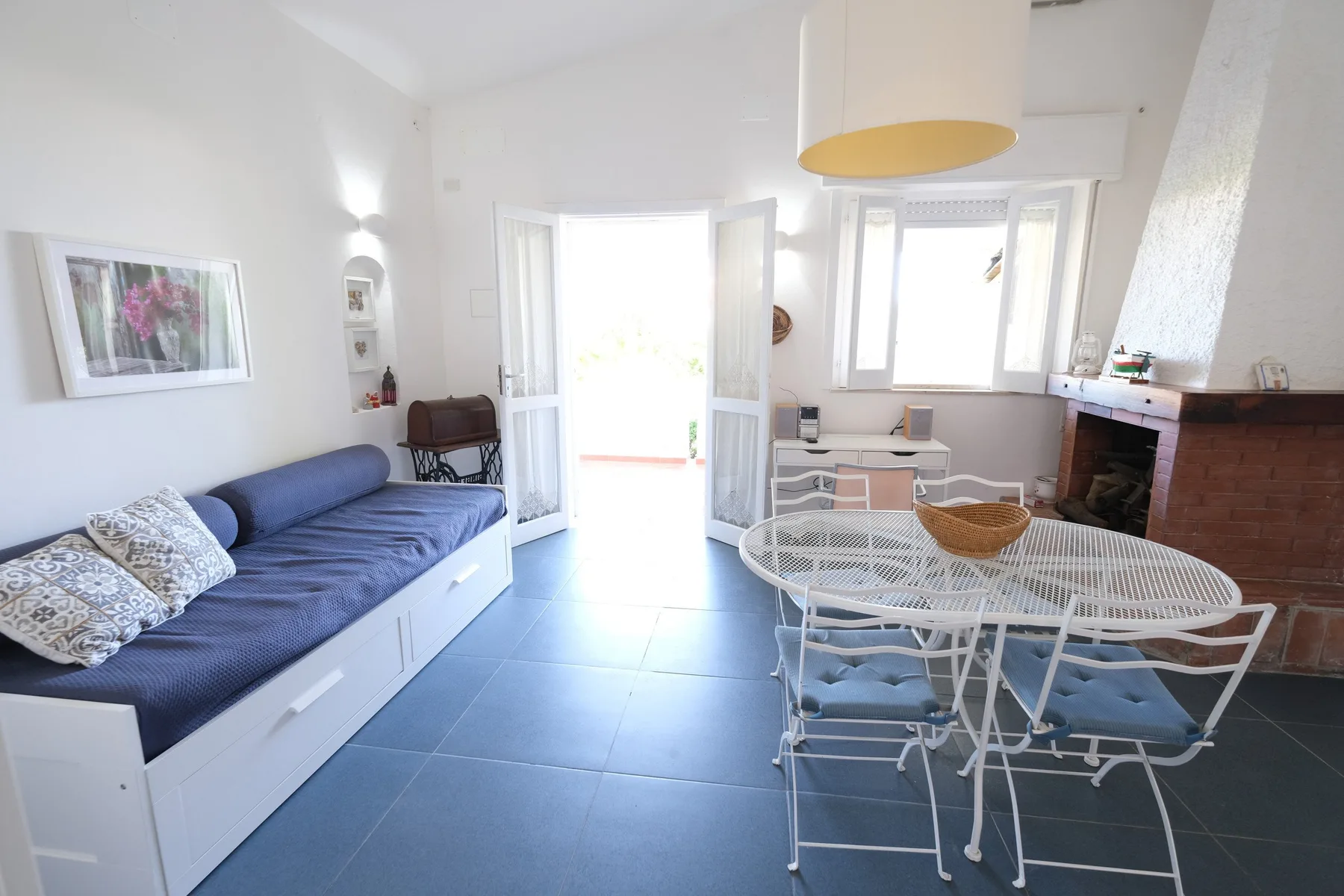 A bright living area with blue seating and a round dining table.