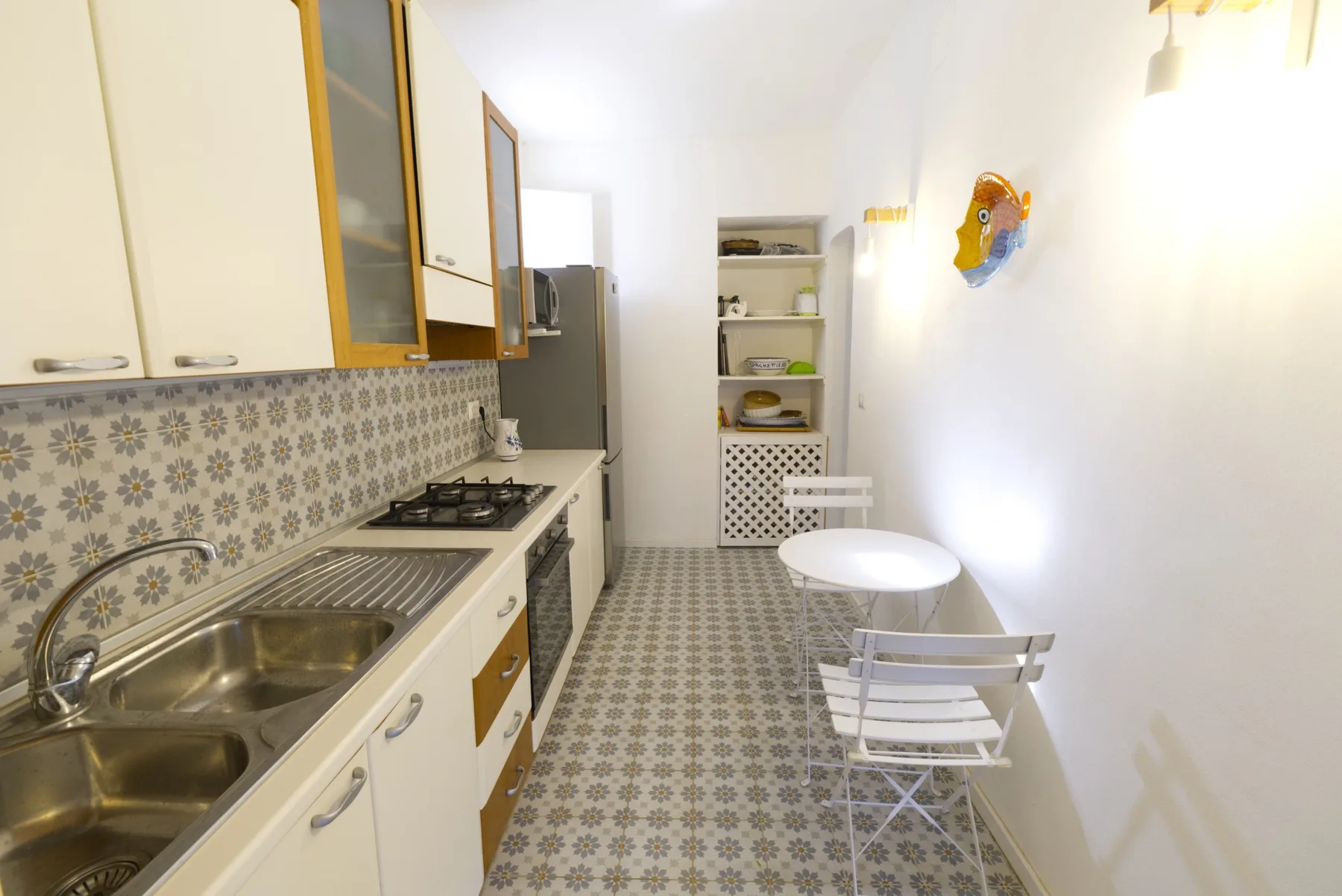 A narrow kitchen with a long counter and a small dining table.