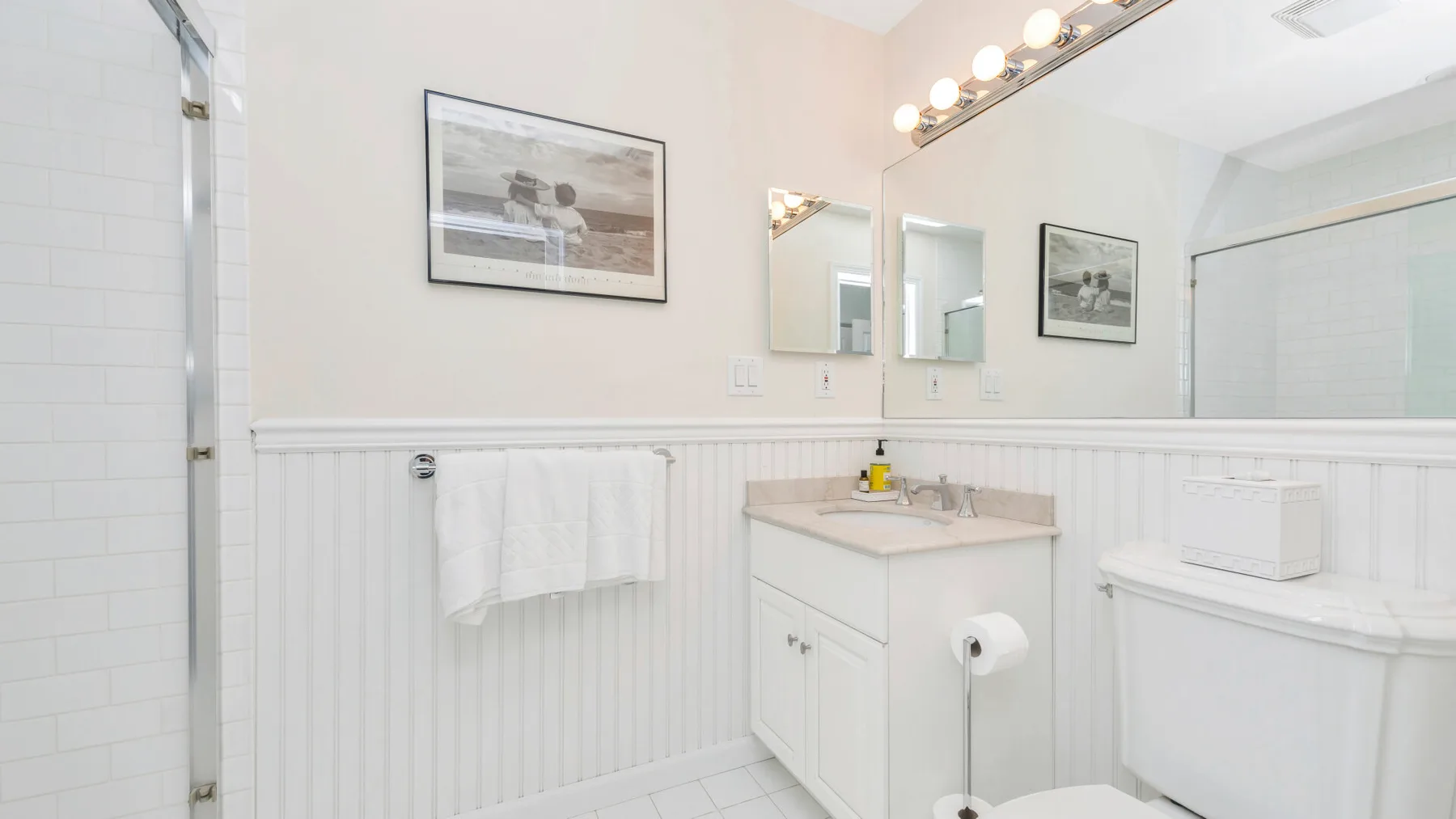 Un baño luminoso con lavabo, espejo y bañera.