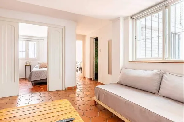 A bright living room with seating beside a large window.
