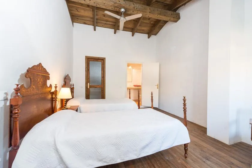 Un dormitorio con una cama de madera y techo de vigas expuestas.