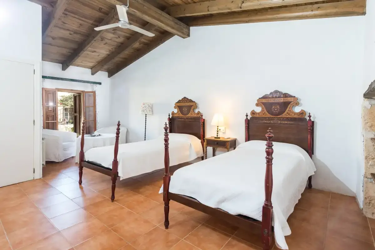 Un dormitorio con dos camas bajo un techo con vigas de madera.
