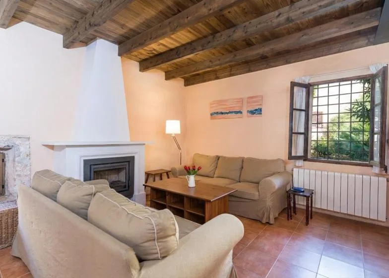 Una sala de estar con asientos alrededor de una mesa de centro de madera junto a una chimenea.