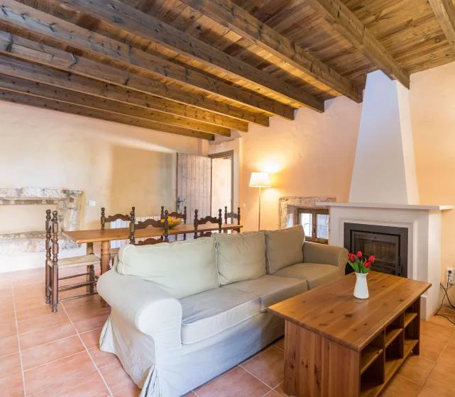 Una sala de estar con asientos, una mesa de centro de madera y una chimenea.