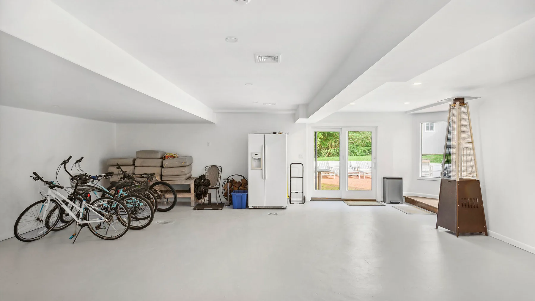 Un espacio interior de almacenamiento luminoso con bicicletas y equipo de ejercicio.