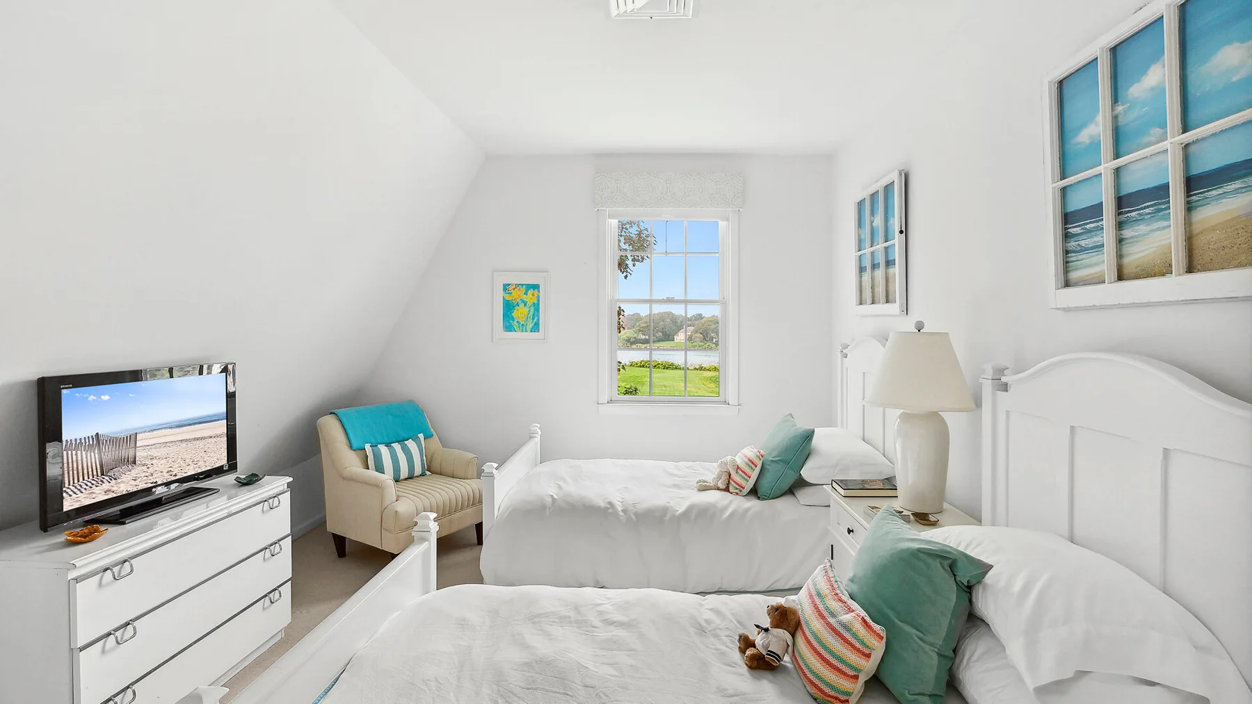 Un dormitorio luminoso con ropa de cama blanca, una ventana y un televisor.