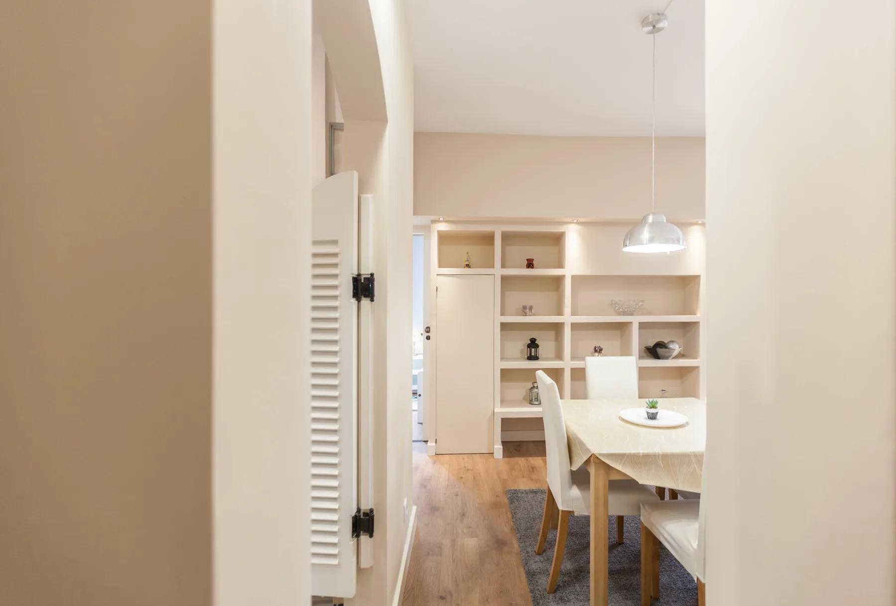A dining area with a table and built-in shelving.
