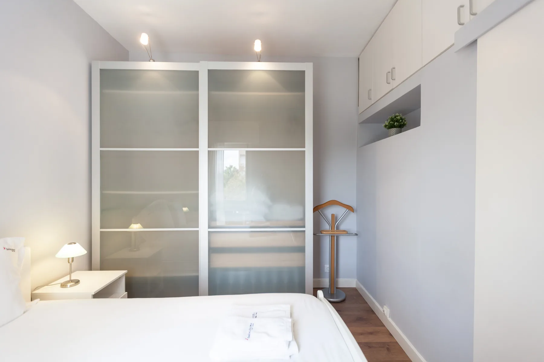 Bedroom with a bed, bedside table, and built-in storage.