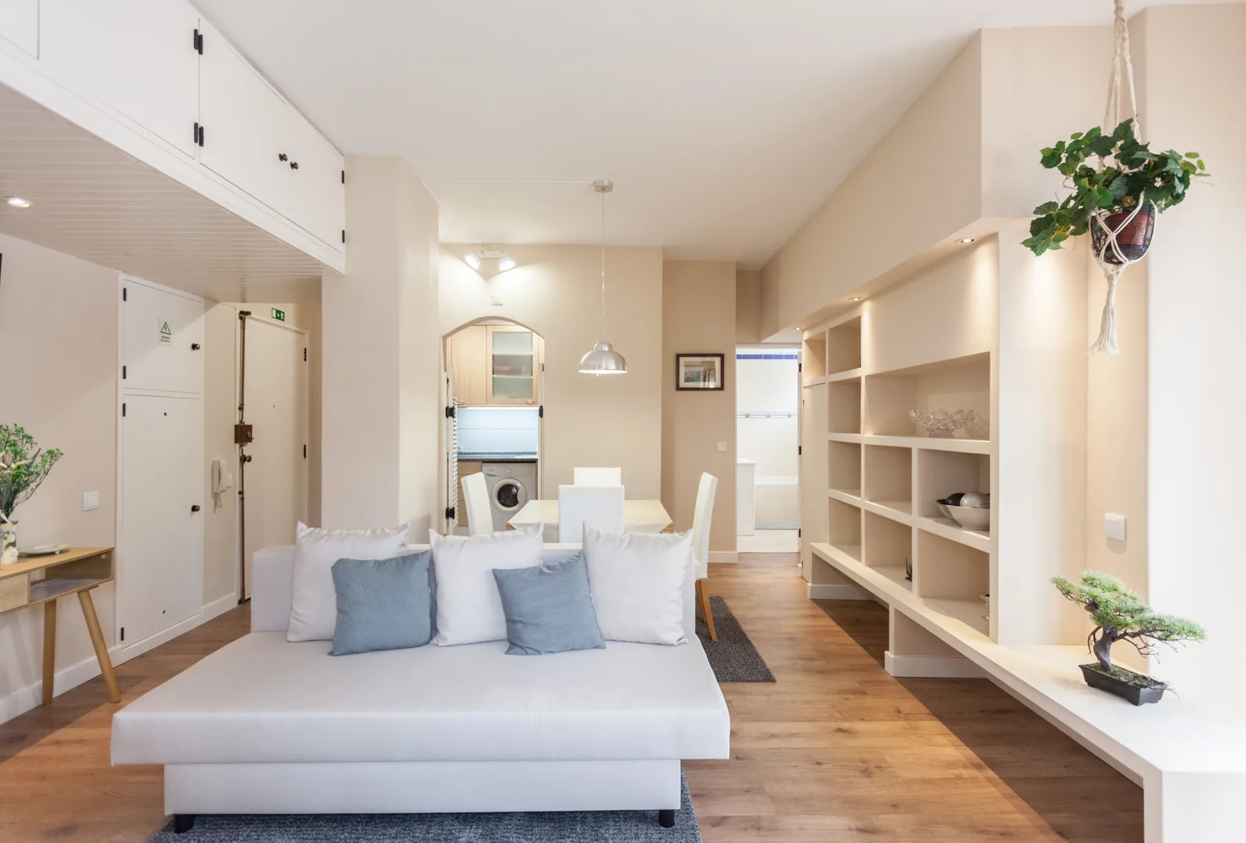A bright living and dining area with seating and built-in shelving.