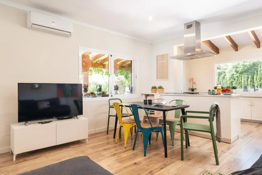 A bright dining area with colorful seating beside a kitchen island.