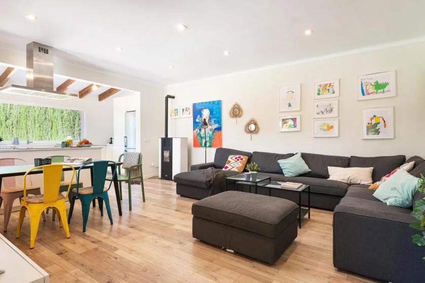 A living room with a sectional seating area beside an open dining space.