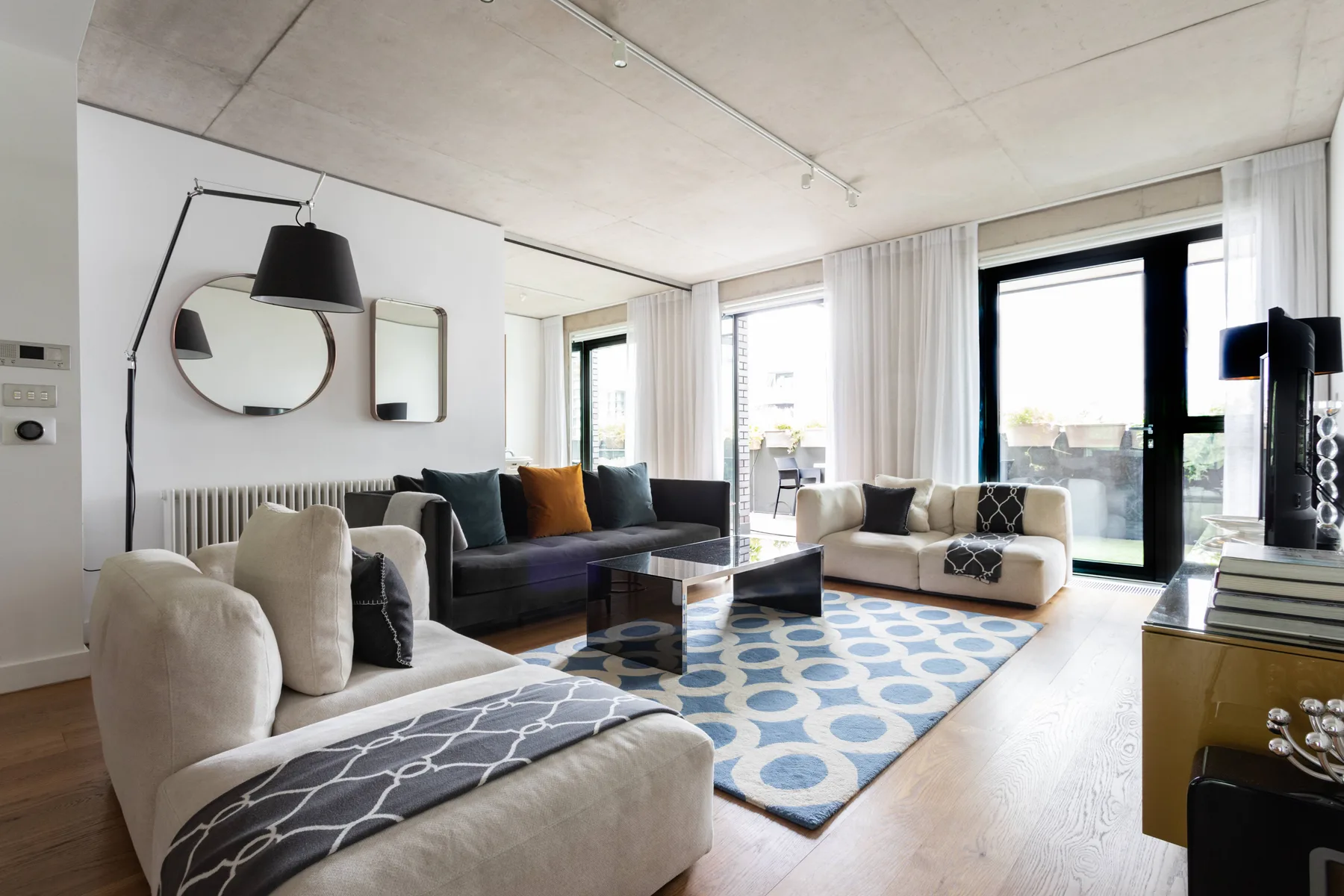 Bright living room with seating arranged around a coffee table and patterned rug.
