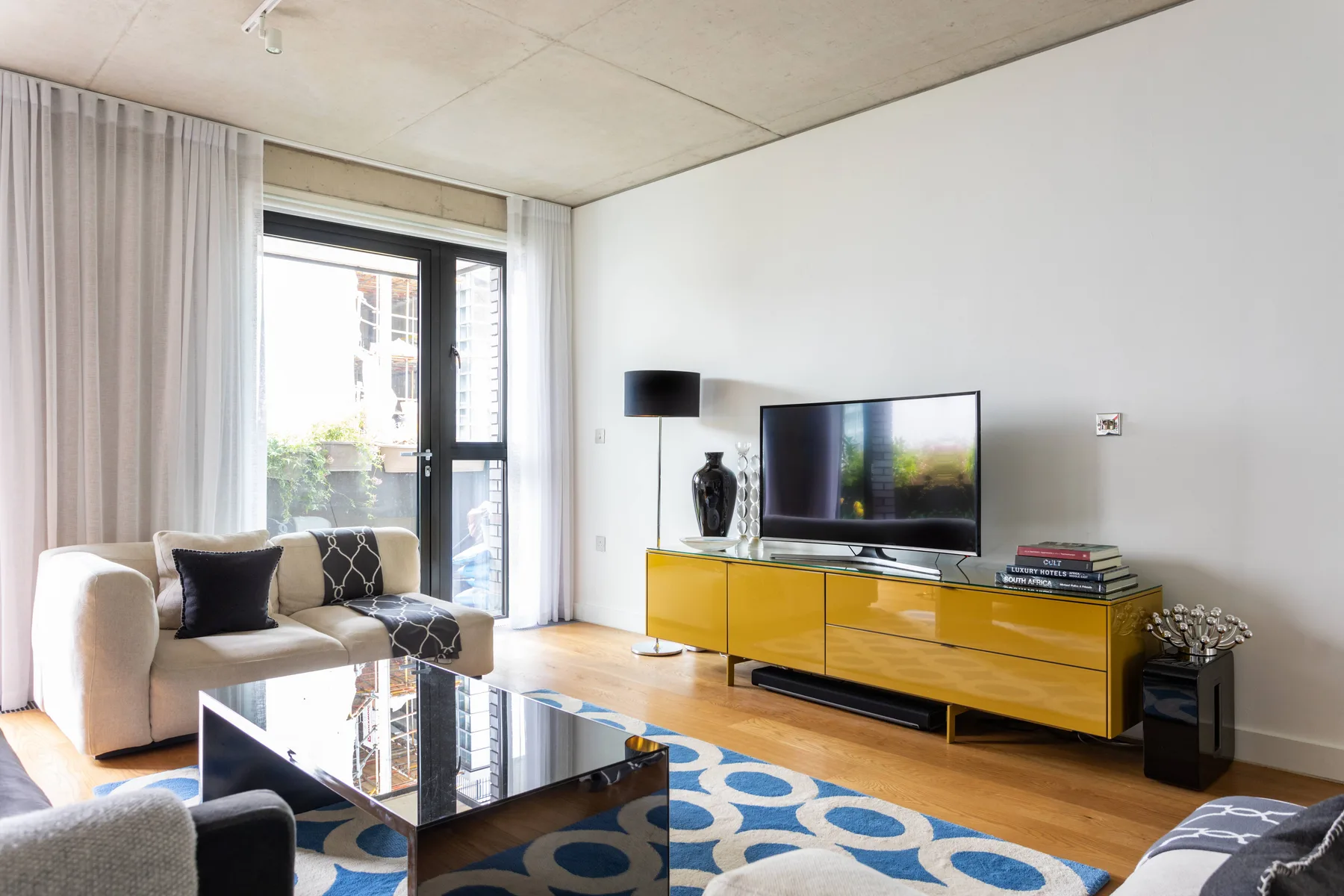 Living room with seating, a television, and a glass coffee table.