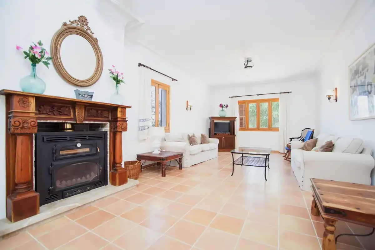 A bright living room with seating arranged around a coffee table and fireplace.