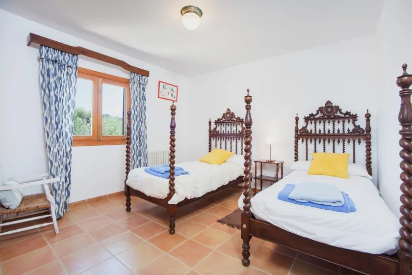 A bedroom with two beds, each made with white bedding and a yellow accent pillow.