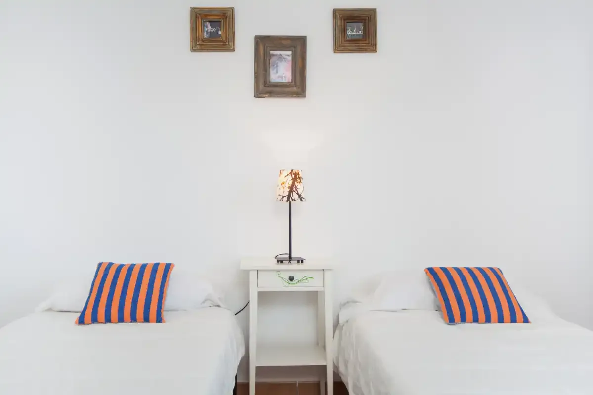 A bedroom with two single beds and a small table between them.