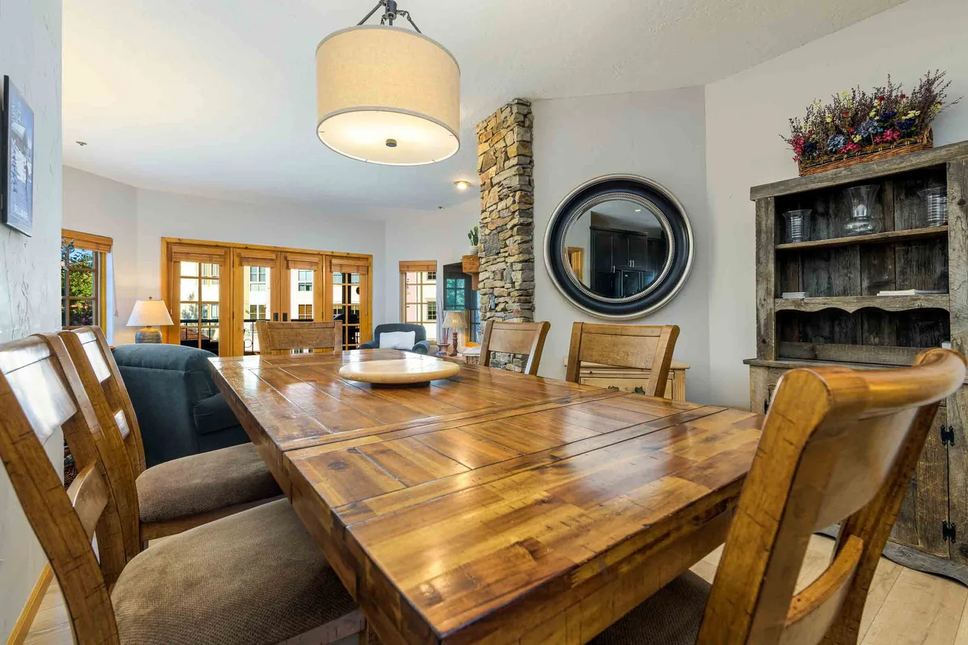 Un comedor con una mesa larga de madera, sillas y una chimenea de piedra.